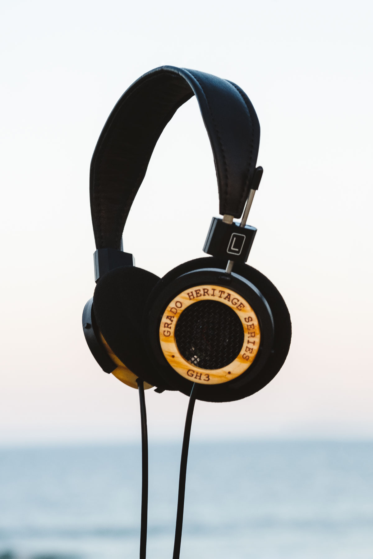 Photo of GH3 Headphones levitating in front of a view of the ocean and the sky.