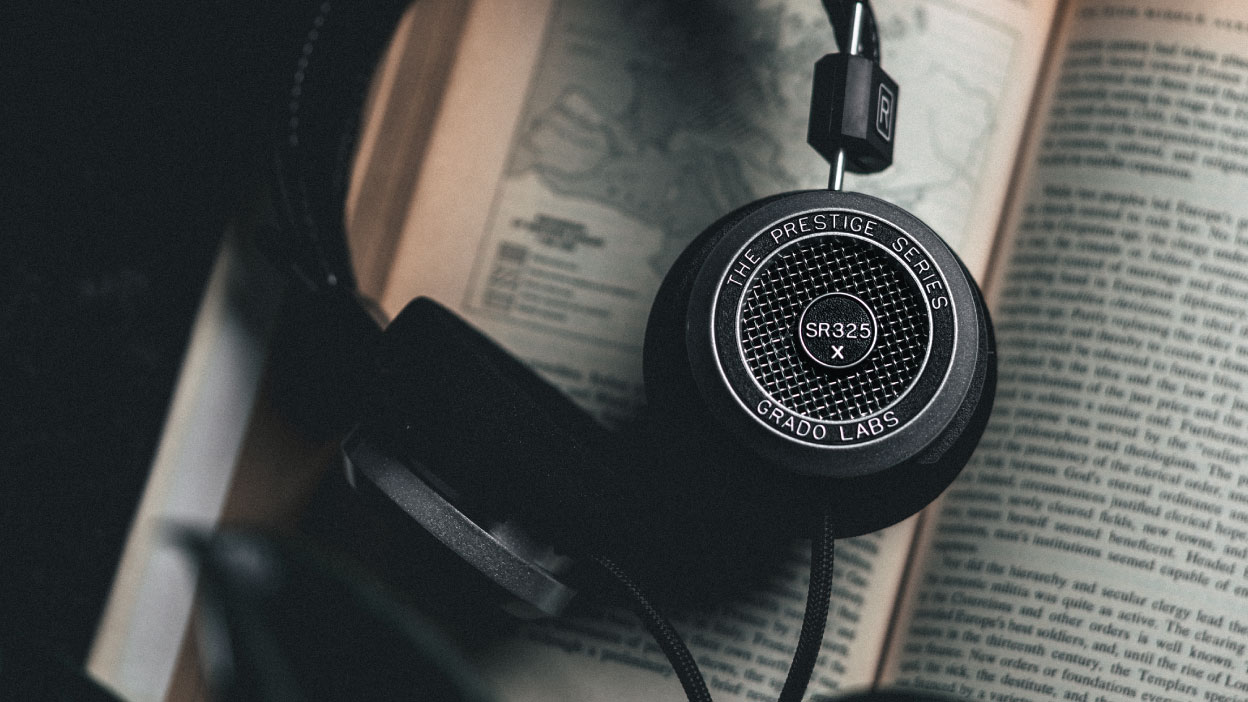 Photo of the sr325x headphones resting on an open book.