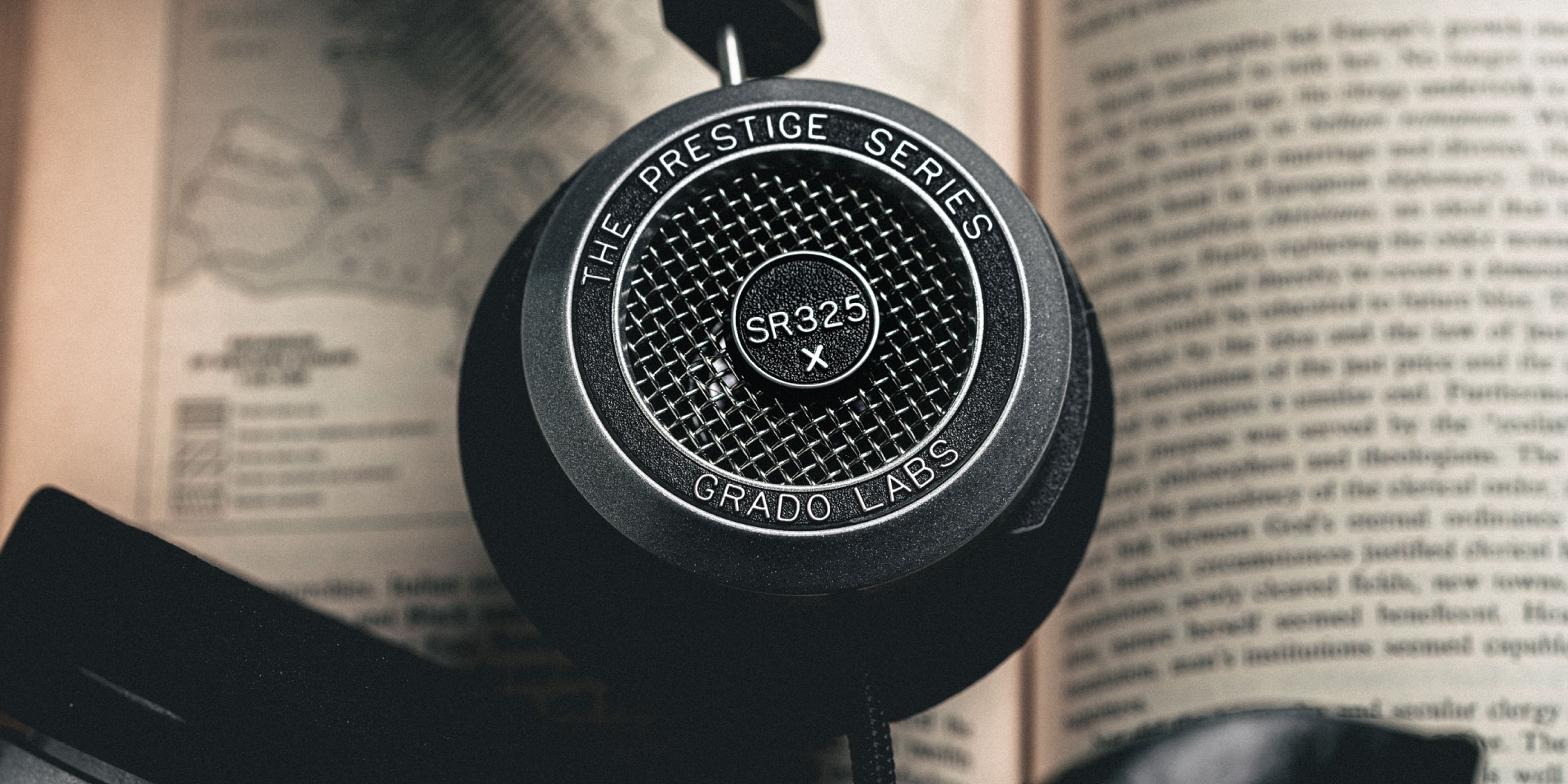 Photo of SR325x headphones sitting on top of an open book.