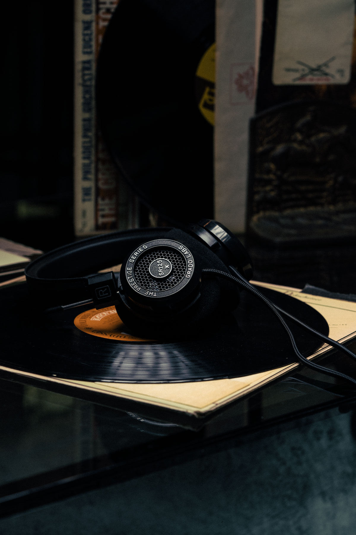 Photo of SR125X headphones resting on a record on top of a glass table