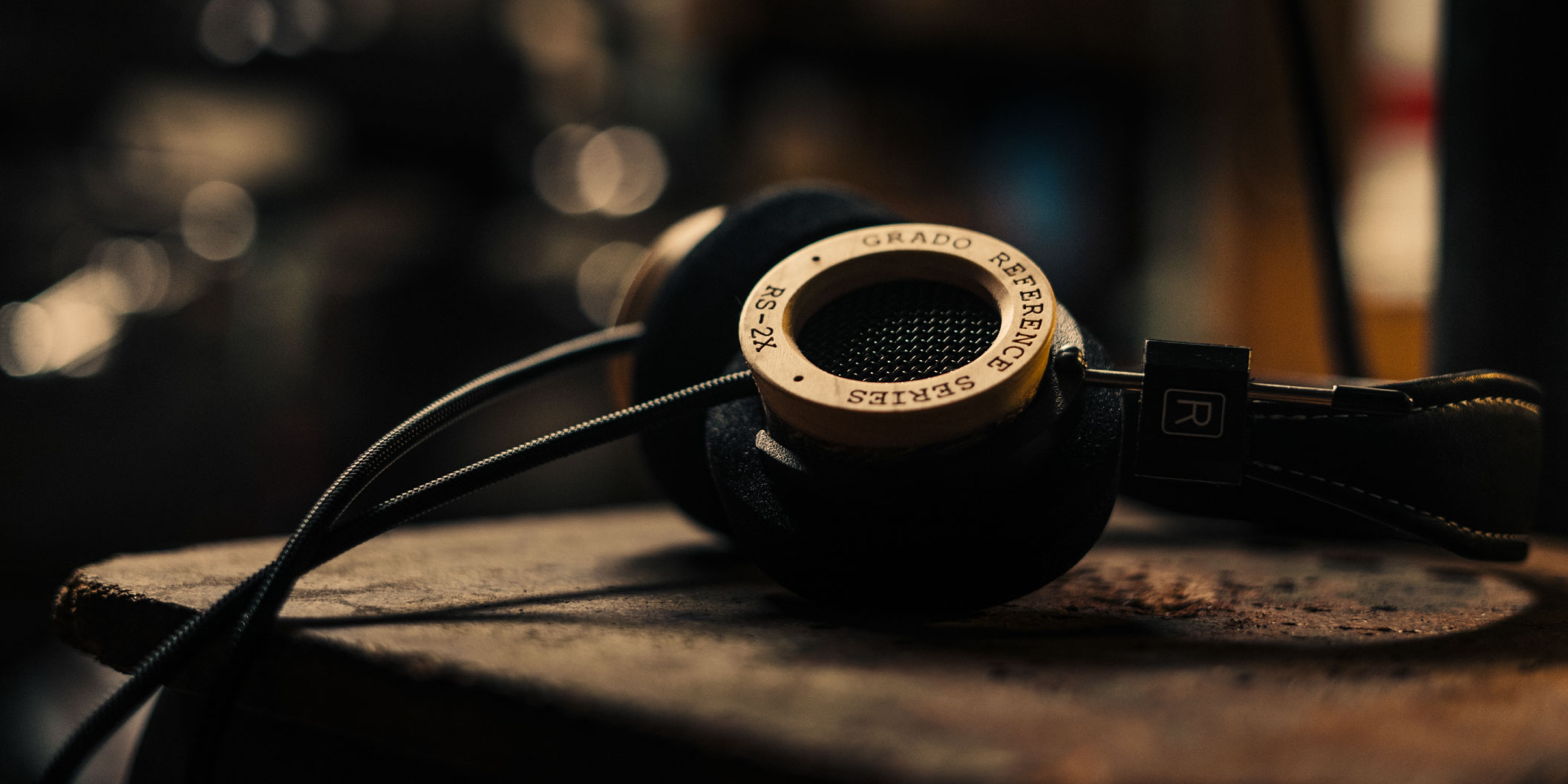 Photo of RS2S Headphones resting on a wooden table with a blurred background